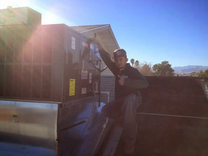 HVAC technician performing HVAC Inspection on a rooftop unit in The Pinery